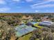 Aerial view of the tennis courts showcasing a well-maintained playing surface and surrounding greenery at 13032 Pinnacle Ln, Hudson, FL 34669