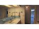 Bathroom with a vanity, blue tile backsplash, and a glimpse into the kitchen at 1414 Grand Blvd, Holiday, FL 34690