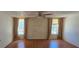 Bedroom with two windows, curtains, ceiling fan, and hardwood floors at 1414 Grand Blvd, Holiday, FL 34690