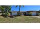 Charming single-story home featuring stone accents, lush landscaping, and a well-maintained front yard at 1414 Grand Blvd, Holiday, FL 34690
