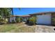Well-maintained single story home with an attached garage and mature landscaping at 1414 Grand Blvd, Holiday, FL 34690