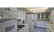 Kitchen featuring white appliances, cabinets, and tile flooring at 1414 Grand Blvd, Holiday, FL 34690