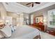 A luxurious main bedroom featuring a tray ceiling and a spacious dresser with a large mirror at 2425 Tarragon Ln, New Port Richey, FL 34655