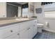 Bathroom featuring a sink, commode, and a large mirror, with blue tile flooring at 3606 Dow Ln, Spring Hill, FL 34609
