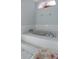 Close-up of a white bathtub with decorative handles and tiled surround with small pink tiles at 3606 Dow Ln, Spring Hill, FL 34609