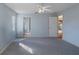 Large bedroom with light blue walls and carpet flooring, ceiling fan and two doors at 3606 Dow Ln, Spring Hill, FL 34609
