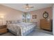 Bedroom with a floral bedspread, a ceiling fan, and a window overlooking the backyard at 3606 Dow Ln, Spring Hill, FL 34609
