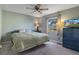 Comfortable bedroom featuring a ceiling fan, a window view and a TV atop a blue dresser at 3606 Dow Ln, Spring Hill, FL 34609