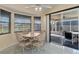 Bright dining area with tile floor, bay windows, and sliding glass doors to the screened-in lanai at 3606 Dow Ln, Spring Hill, FL 34609