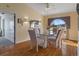Light and airy dining room with a glass table, elegant chairs, and a decorative window at 3606 Dow Ln, Spring Hill, FL 34609