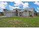 Charming single-story home with a well-manicured lawn, two car garage, and beautiful architectural details at 3606 Dow Ln, Spring Hill, FL 34609