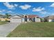 Charming single Gathering home features a 2-car garage and well-maintained lawn under a cloudy blue sky at 3606 Dow Ln, Spring Hill, FL 34609