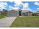 Charming single-story home with a well-manicured lawn, two car garage, and beautiful architectural details at 3606 Dow Ln, Spring Hill, FL 34609