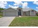 Charming single-story home with a well-manicured lawn, two car garage, and beautiful architectural details at 3606 Dow Ln, Spring Hill, FL 34609