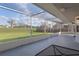 Enclosed lanai offering a private outdoor retreat with views of the lush backyard and open sky at 3606 Dow Ln, Spring Hill, FL 34609
