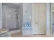 Shower with glass enclosure, grab bar, and a small rack with stacked towels on a metal table at 3606 Dow Ln, Spring Hill, FL 34609