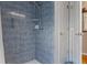 Tiled shower with shower head and controls, adjacent to a white door in the bathroom at 3606 Dow Ln, Spring Hill, FL 34609