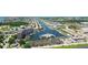 Wide aerial view showcasing a waterfront community, canals, lush greenery, and nearby commercial areas at 5015 Us Highway 19 # 307, New Port Richey, FL 34652