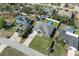 Aerial view of a residence featuring a well-kept lawn, pool, and surrounded by trees in a neighborhood setting at 5139 Jenson Ave, Spring Hill, FL 34608