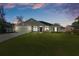 Charming home at twilight features a lush green lawn, two-car garage, and covered porch at 5139 Jenson Ave, Spring Hill, FL 34608
