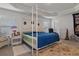 Spacious main bedroom featuring a four-poster bed, windows, and neutral decor at 5139 Jenson Ave, Spring Hill, FL 34608