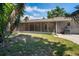 Screened-in back porch with a view of the grassy backyard, mature trees and an exterior chimney at 5345 Carlton Rd, New Port Richey, FL 34652