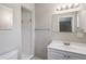 Well-lit bathroom featuring a single sink vanity, mirror, and walk-in shower at 5345 Carlton Rd, New Port Richey, FL 34652