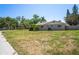 A well-manicured lawn enhances this home's curb appeal, complemented by mature trees and a side street view at 5345 Carlton Rd, New Port Richey, FL 34652