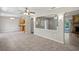 Spacious living room with tile flooring, fireplace, ceiling fans, and open concept design leading to the kitchen at 5345 Carlton Rd, New Port Richey, FL 34652