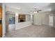 Open-concept living room with tile floors, a stone fireplace, and seamless flow to the adjacent kitchen and sunroom at 5345 Carlton Rd, New Port Richey, FL 34652