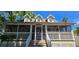 Exterior shot featuring a charming screened porch, white railings, and wooden stairs leading to the entrance at 5748 Massachusetts Ave, New Port Richey, FL 34652