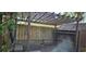 Wooden pergola offering shade and seating on a patio with a view of a weathered wooden fence at 5800 Massachusetts Ave, New Port Richey, FL 34652