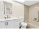 Clean bathroom with white vanity, matching toilet and bathtub with accessibility rail for convenience at 6387 Plantation Rd, Spring Hill, FL 34606