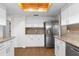 Spacious kitchen with stainless steel refrigerator, white cabinets, and granite countertops for ample cooking space at 6387 Plantation Rd, Spring Hill, FL 34606