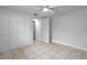 Neutral bedroom with a ceiling fan, closet, and tile floors at 6414 Kelso Dr, Port Richey, FL 34668