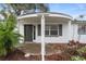 Front porch featuring gray trim, a dark front door, and lush landscaping at 6414 Kelso Dr, Port Richey, FL 34668
