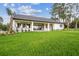Spacious backyard with green grass, putting green, and a covered patio at 6470 Summit View Dr, Brooksville, FL 34601