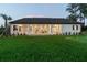 Beautiful backyard features a putting green and expansive lawn, complemented by the home's covered outdoor living area at 6470 Summit View Dr, Brooksville, FL 34601