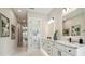 Bright bathroom featuring marble floors, double vanity, modern fixtures, and tasteful decor at 6470 Summit View Dr, Brooksville, FL 34601