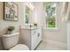 Bathroom featuring a white vanity, decorative mirror, and a window with a view of greenery at 6470 Summit View Dr, Brooksville, FL 34601