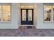 Elegant black double doors with glass panels, framed by sidelights, and a brick paver entryway at 6470 Summit View Dr, Brooksville, FL 34601
