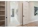 Hallway featuring a storage shelf on the left and leading to a bathroom with tiled shower at 6470 Summit View Dr, Brooksville, FL 34601