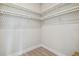 Bright walk-in closet with white wooden floors and white closet organizer system, shelves, and hanging rods at 6470 Summit View Dr, Brooksville, FL 34601
