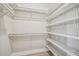 Bright walk-in closet with white wooden floors and white closet organizer system, shelves, and hanging rods at 6470 Summit View Dr, Brooksville, FL 34601
