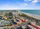 Stunning aerial view of the beach, condos, and surrounding neighborhood along the coastline at 6800 Sunset Way # 1006, St Pete Beach, FL 33706