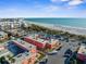 Wide aerial shot of the property's location near the beach, surrounded by tropical vegetation and city skyline at 6800 Sunset Way # 1006, St Pete Beach, FL 33706