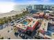 Aerial view of the property with a pool and beach access, surrounded by lush greenery and ample parking at 6800 Sunset Way # 1006, St Pete Beach, FL 33706