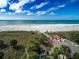 Panoramic beach scene featuring white sand, ocean, beach umbrellas, and coastal vegetation at 6800 Sunset Way # 1006, St Pete Beach, FL 33706