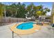 Backyard pool features a unique shape, surrounded by a wooden fence for privacy at 7427 Congress St, New Port Richey, FL 34653
