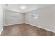 Neutral bedroom with wood-look flooring, white walls and natural light at 7610 Ilex Dr, Port Richey, FL 34668